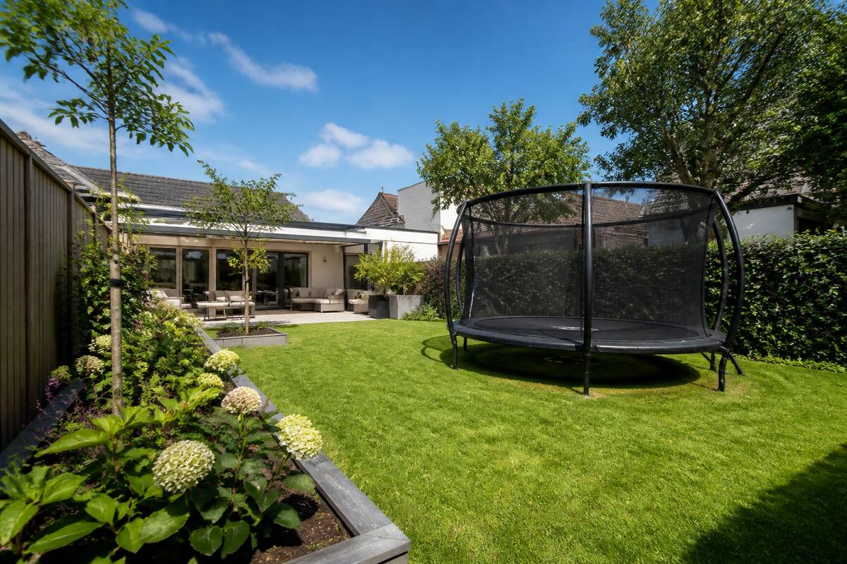 Trampoline met veiligheidsnet in een ruime achtertuin