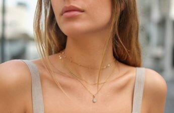 Model draagt halskettingen in verschillende lengtes met subtiele hangertjes onder natuurlijk daglicht