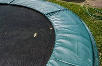 Springmat en randkussen van een trampoline schoonmaken in een tuin